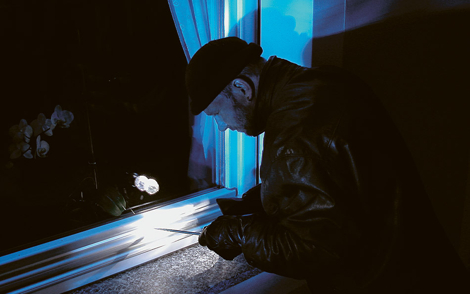 Eine typische Einbruchsituation: Ein Täter versucht das Fenster aufzuhebeln oder den Beschlag zu manipulieren.
